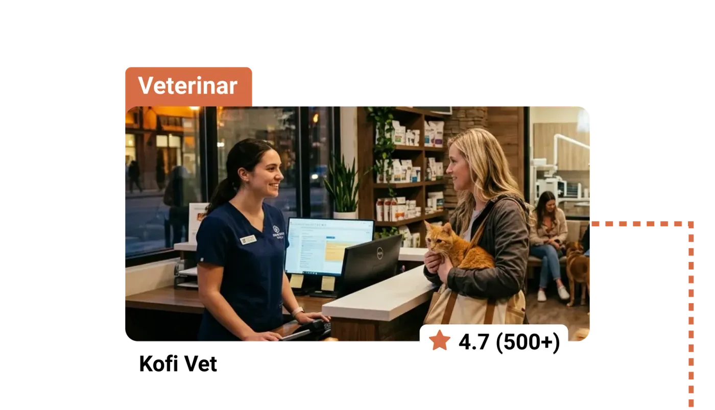 Veterinary clinic front desk: a nurse in navy scrubs at the computer talks with a client holding an orange cat.